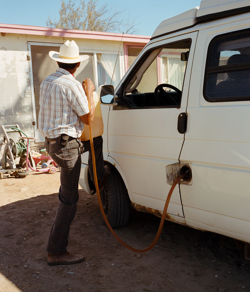 Man filling a van with gas out of a jug in Baja, Mexico