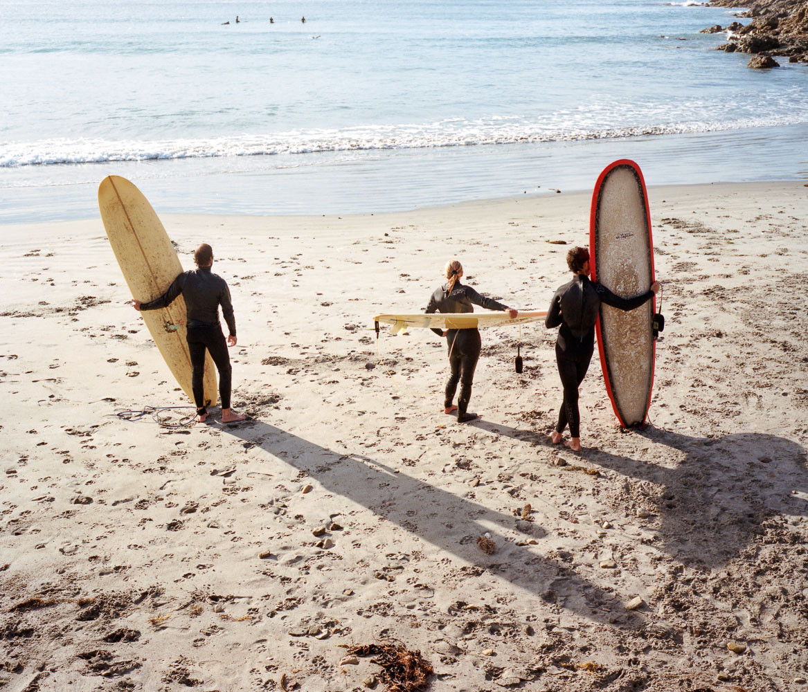 Three surfers on the beach in Baja, Mexico